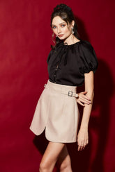 High-waisted A-line silk skirt with structured buckled waistband and tailored front overlap